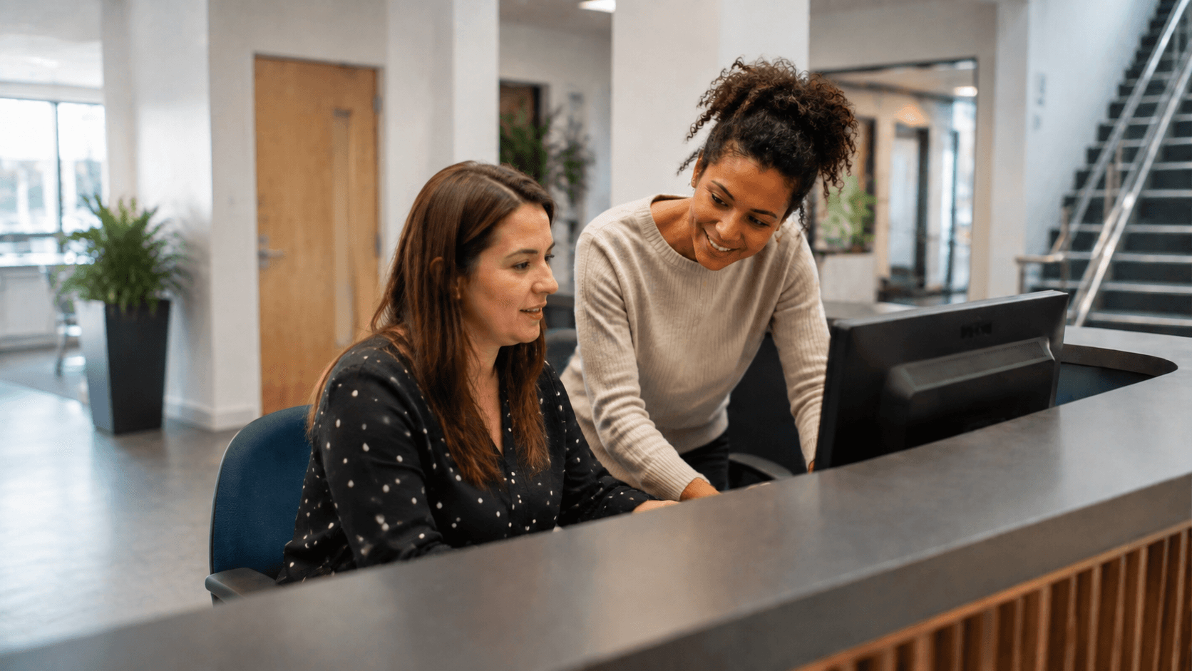 Two members of college staff learning a digital system together