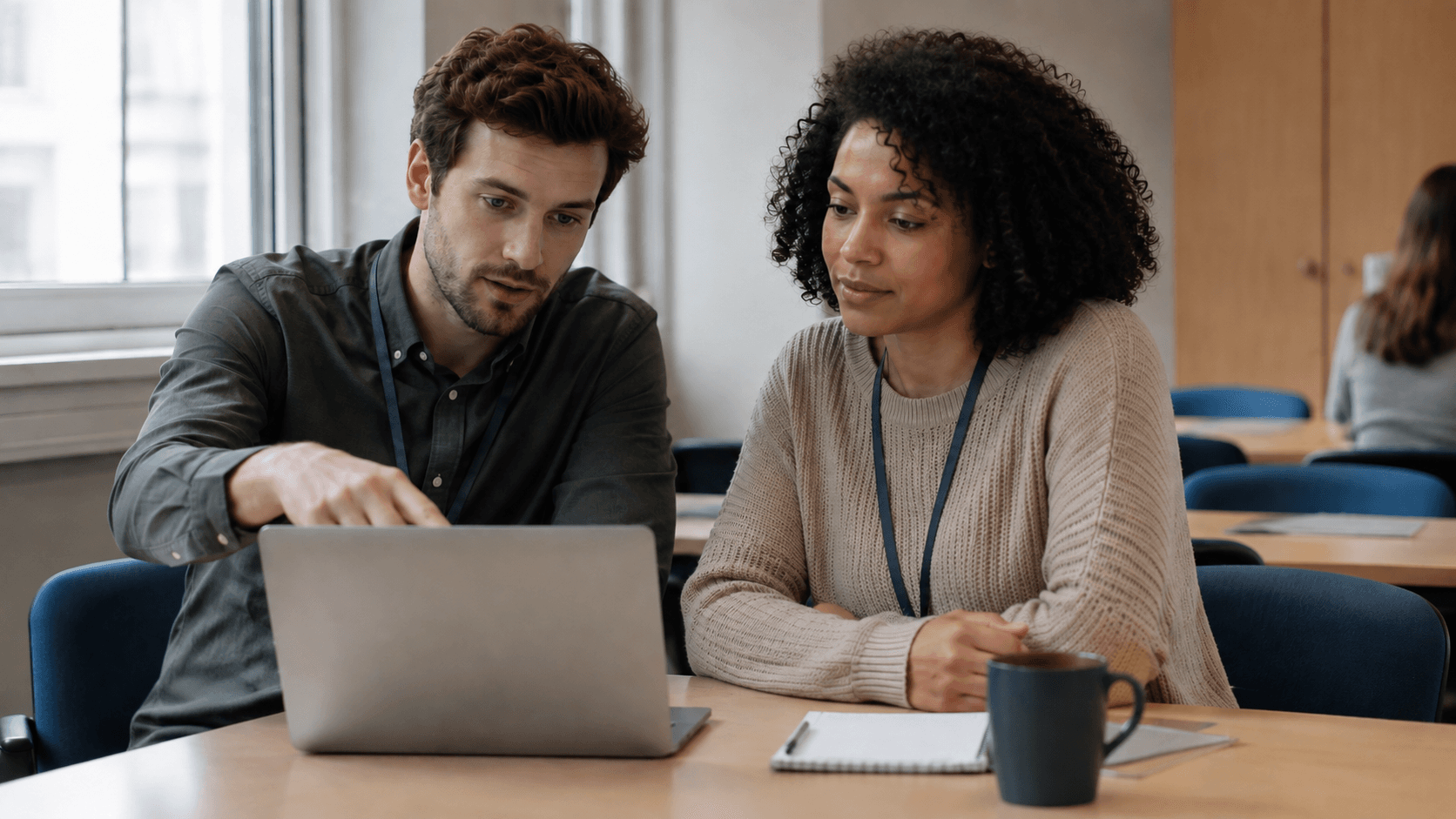 Staff member learning Navigate with a colleague at a college desk